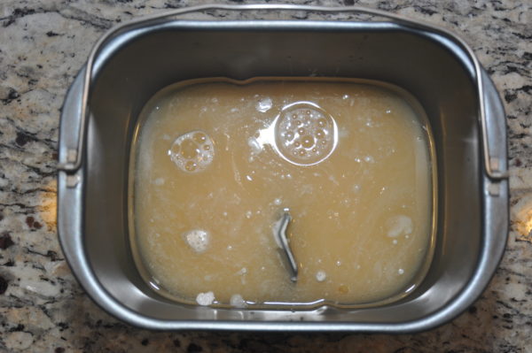 Eggless vanilla cake ingredients in bread machine pan.