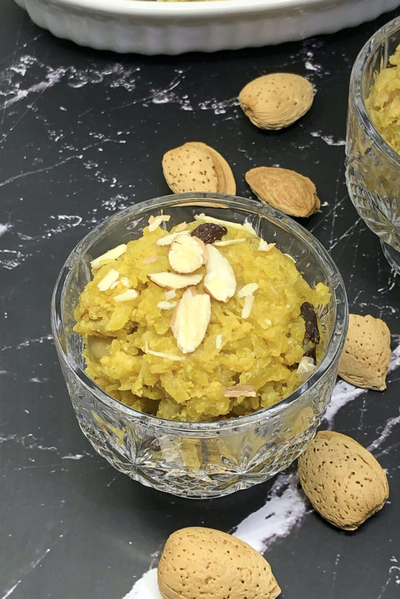 doodhi halwa in a glass bowl with almond shells in background
