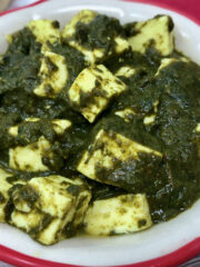 palak paneer in a bowl with roti in background