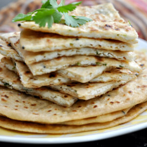 cut paneer paratha stacked in a plate