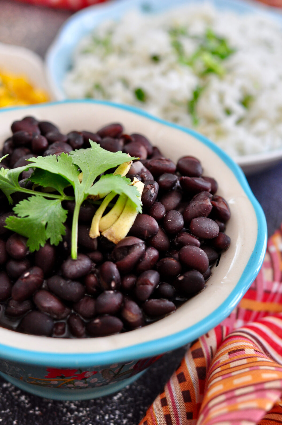 black beans in a bowl garnished with cilantro and ginger slices