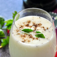 buttermilk in a glass and garnished with roasted cumin powder and mint leaves.