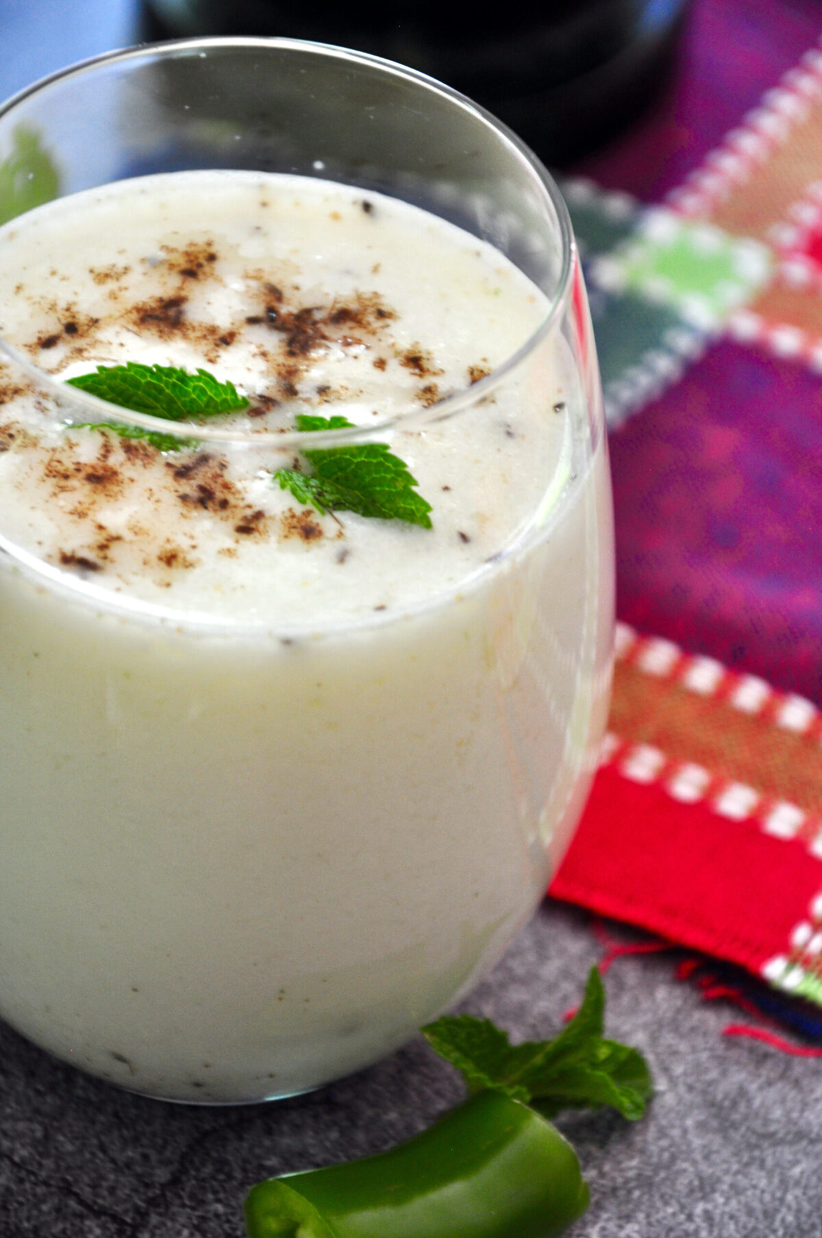 spiced buttermilk in a glass and garnished with roasted cumin powder and mint leaves