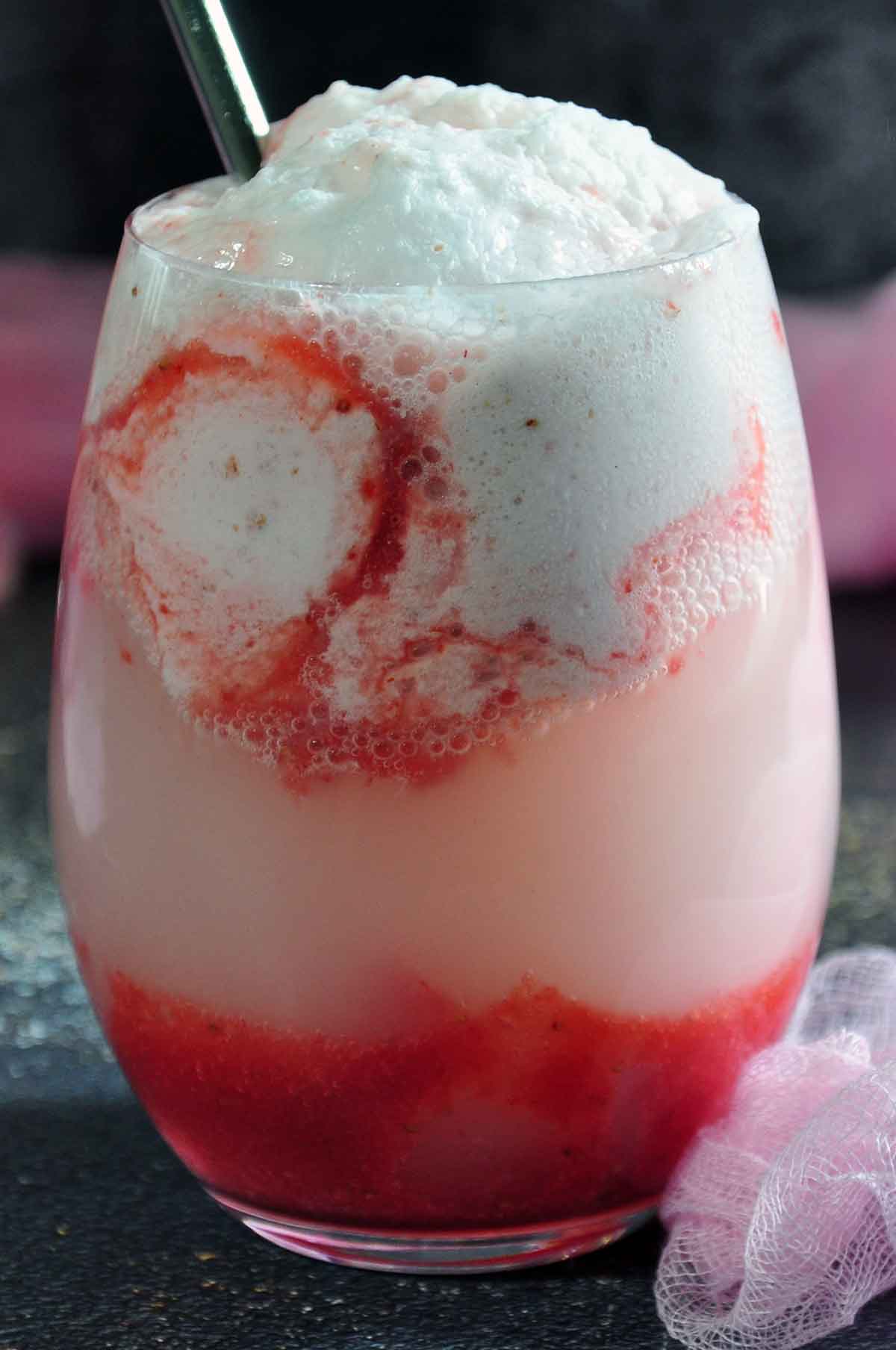 Close-up of Strawberry Float in a stemless wine glass and a tall glass in the background.