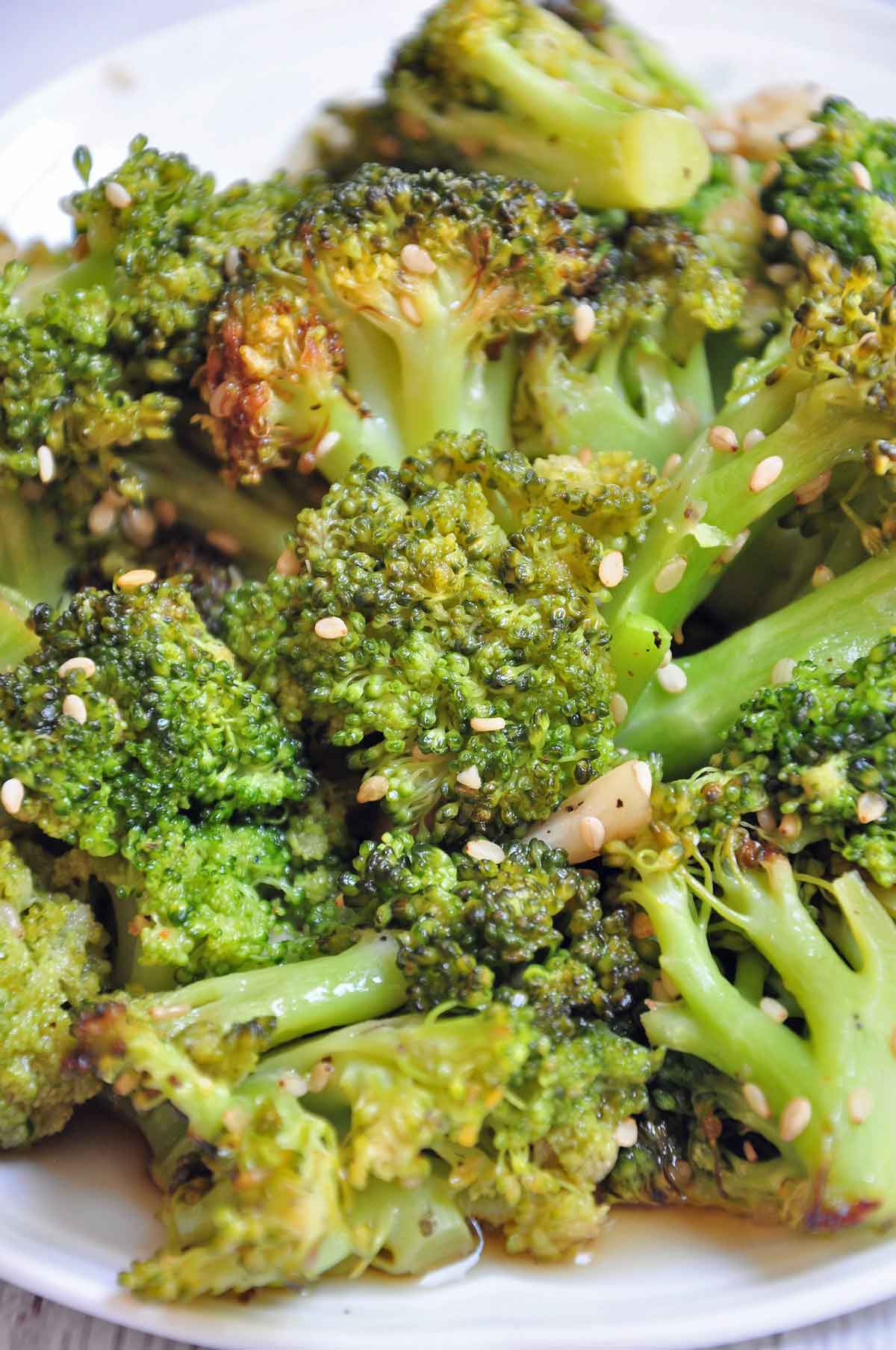 Air fried broccoli in a plate and garnished with sesame seeds.