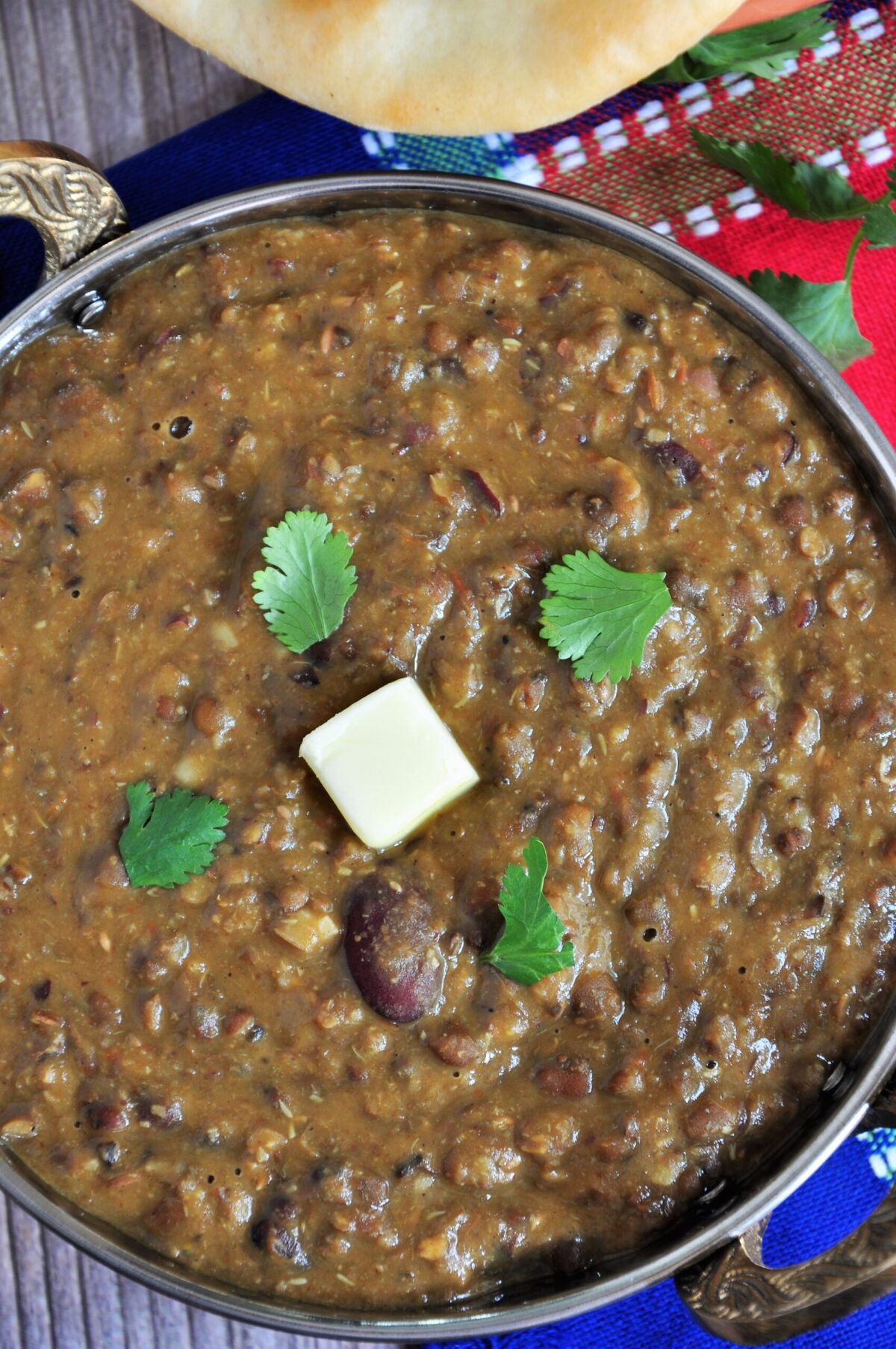 Dal Makhani in a serving wok and garnished with cilantro and butter.