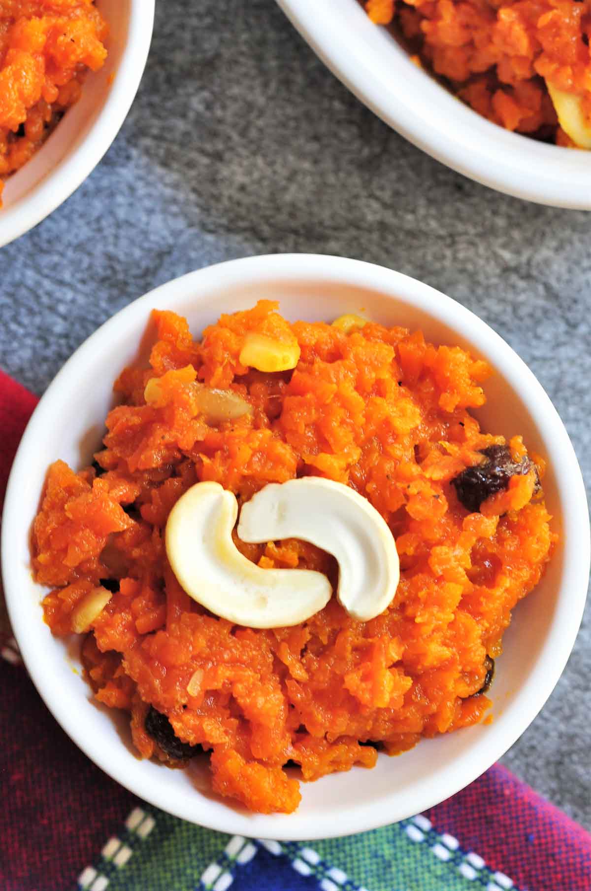 Carrot Halwa in a bowl and garnished with split cashew nut.