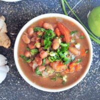 Pinto beans soup in a bowl, garnished with cilantro.