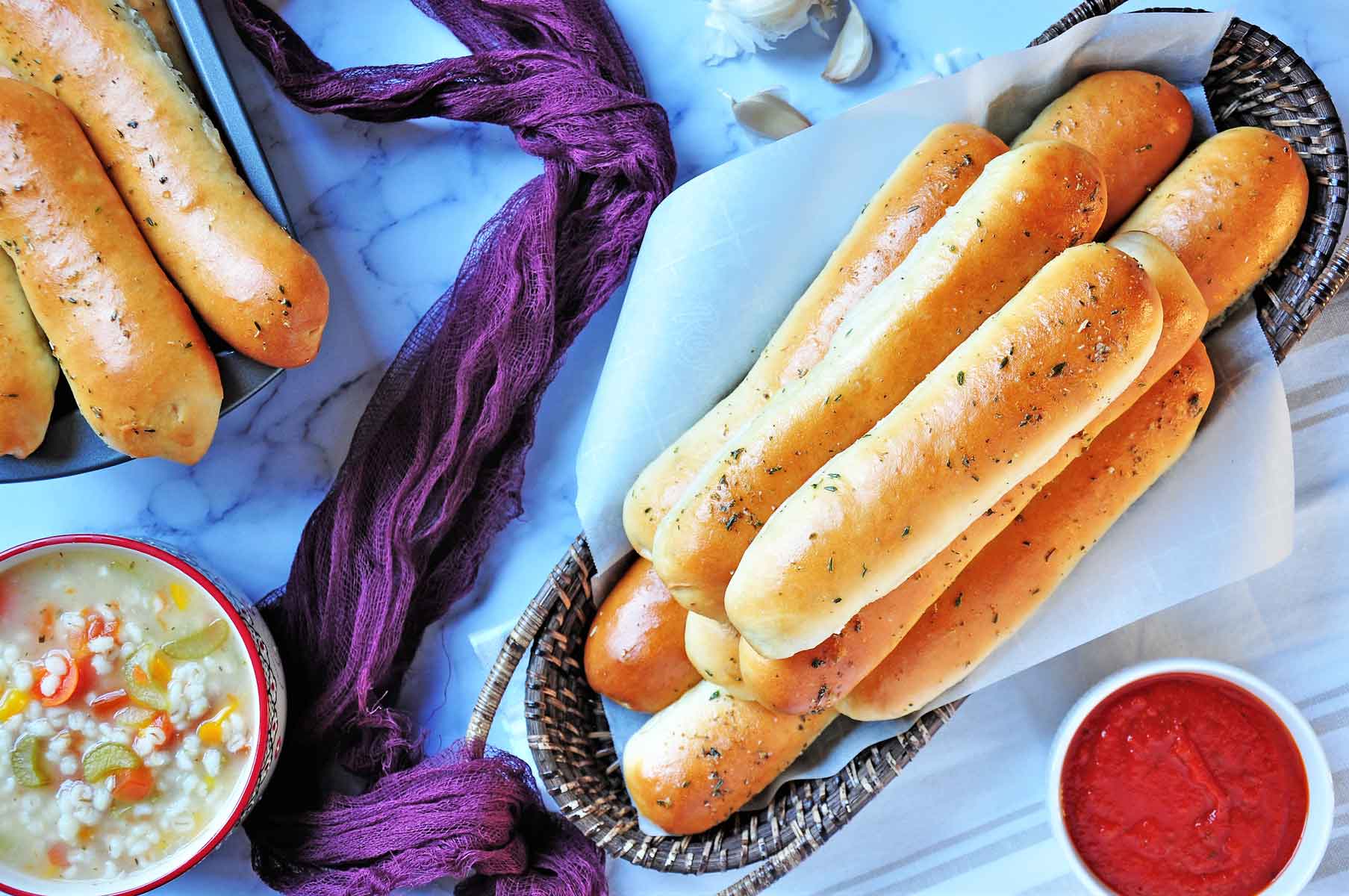 Garlic bread sticks in a wicker basket and marina sauce.