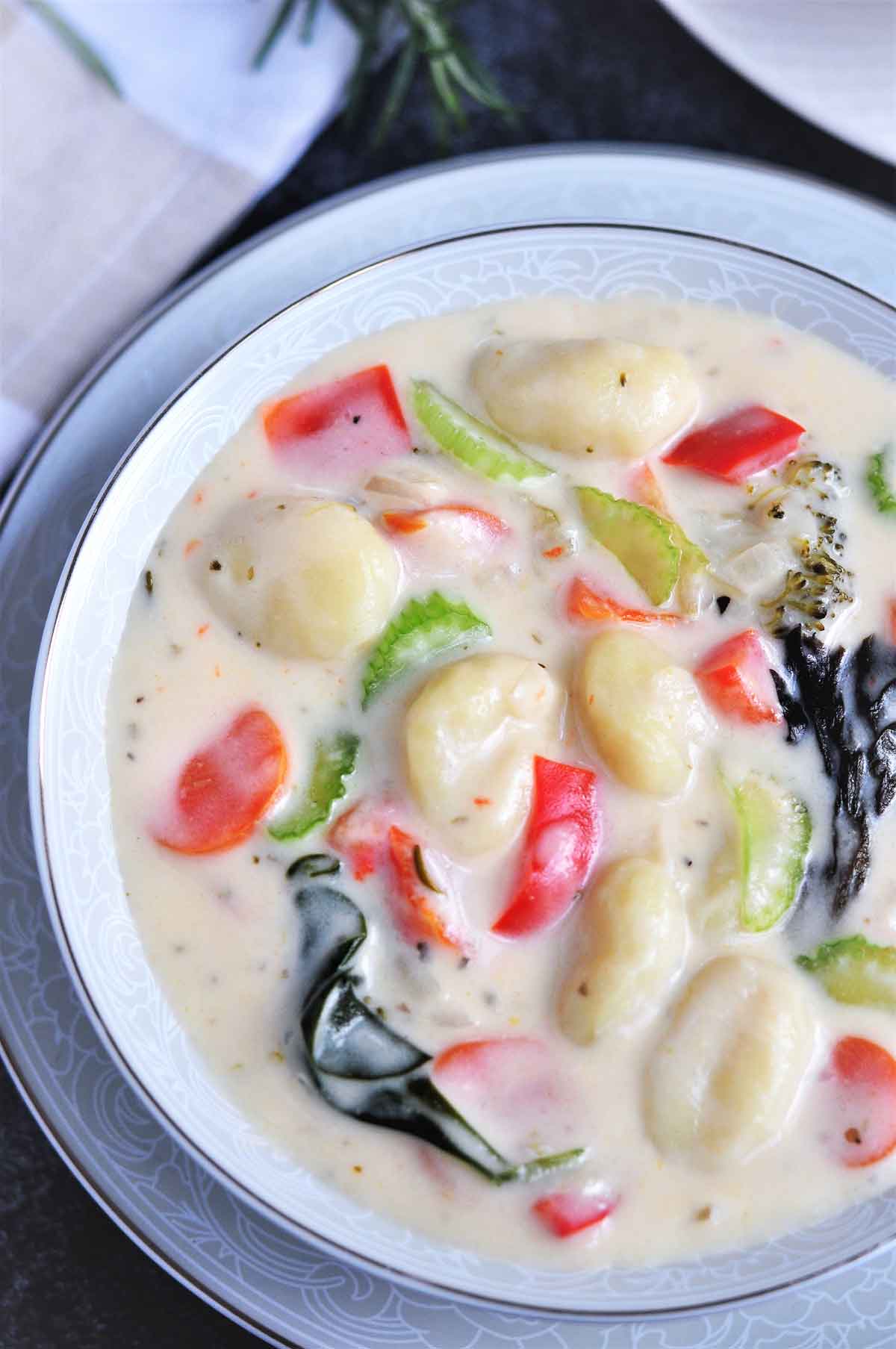 Gnocchi soup with vegetables served in a bowl.