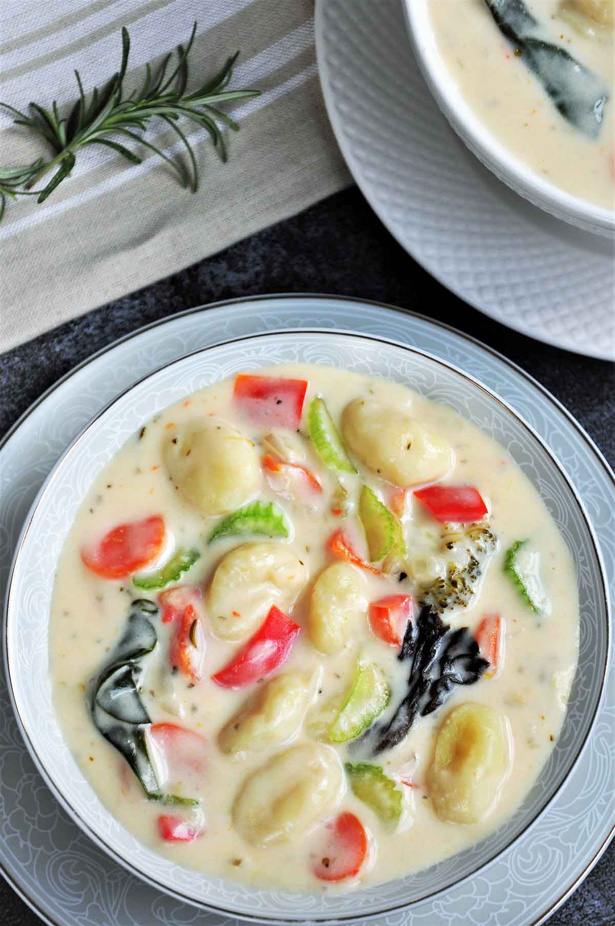 Gnocchi soup with vegetables served in a bowl.