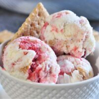 Strawberry cheesecake ice cream scoops in a bowl.