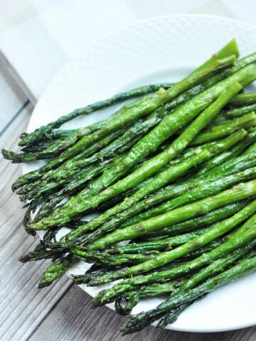Air fried frozen asparagus served in a plate.