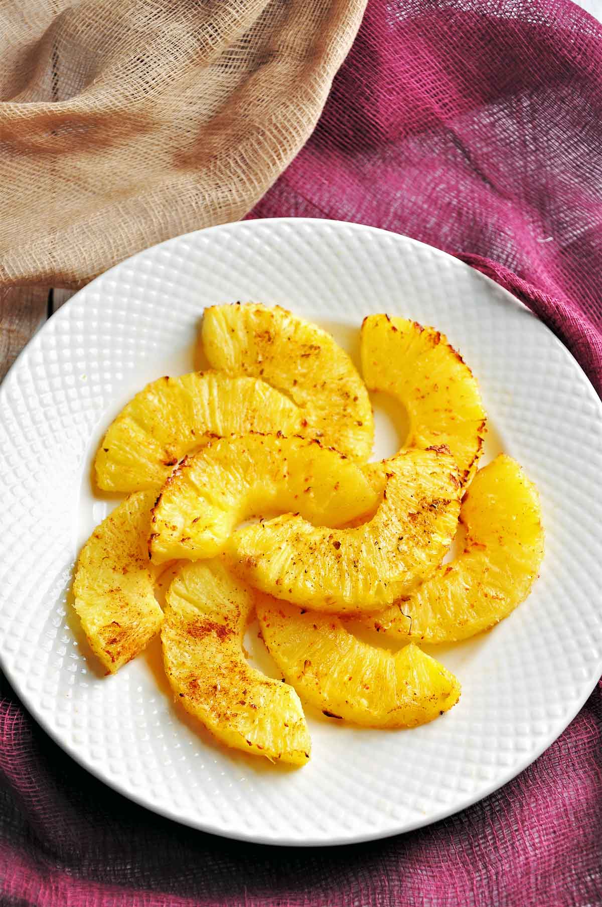 Air fryer roasted pineapple chunks served in a plate,