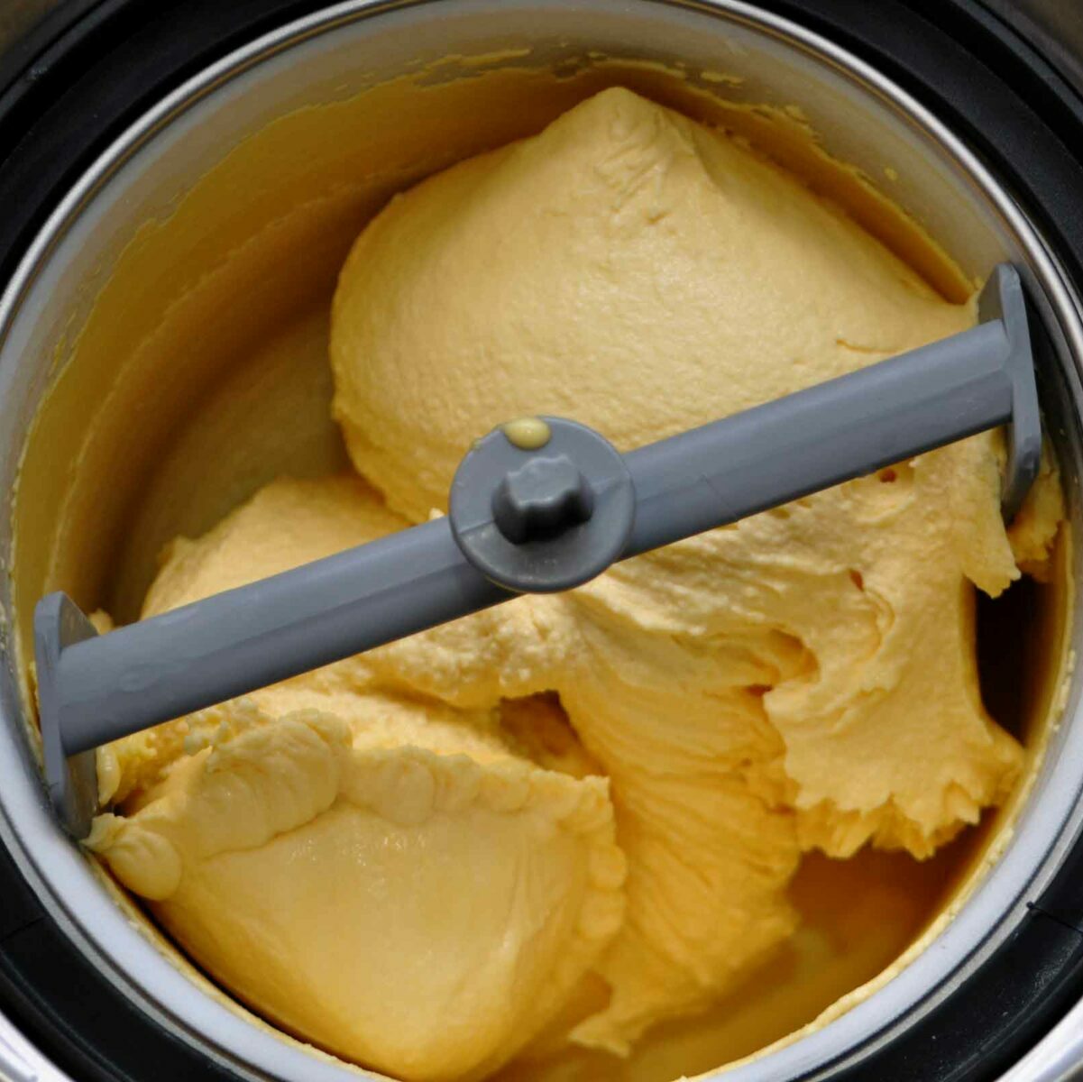 Churn mango mix for mango ice cream.