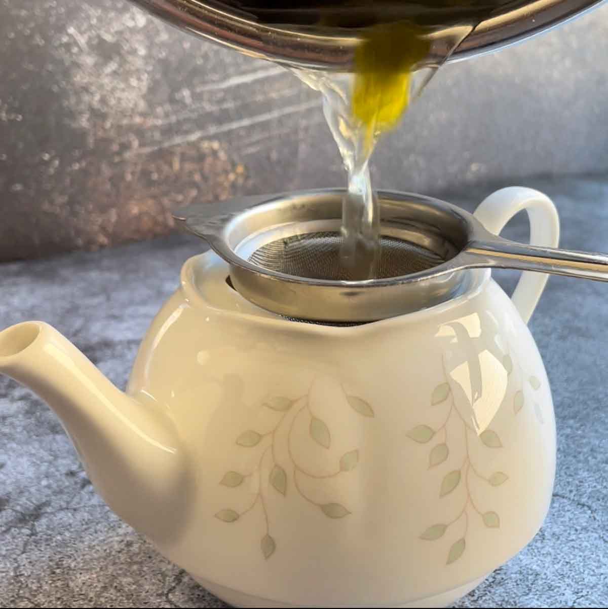 Filtering lemongrass in a tea pot.