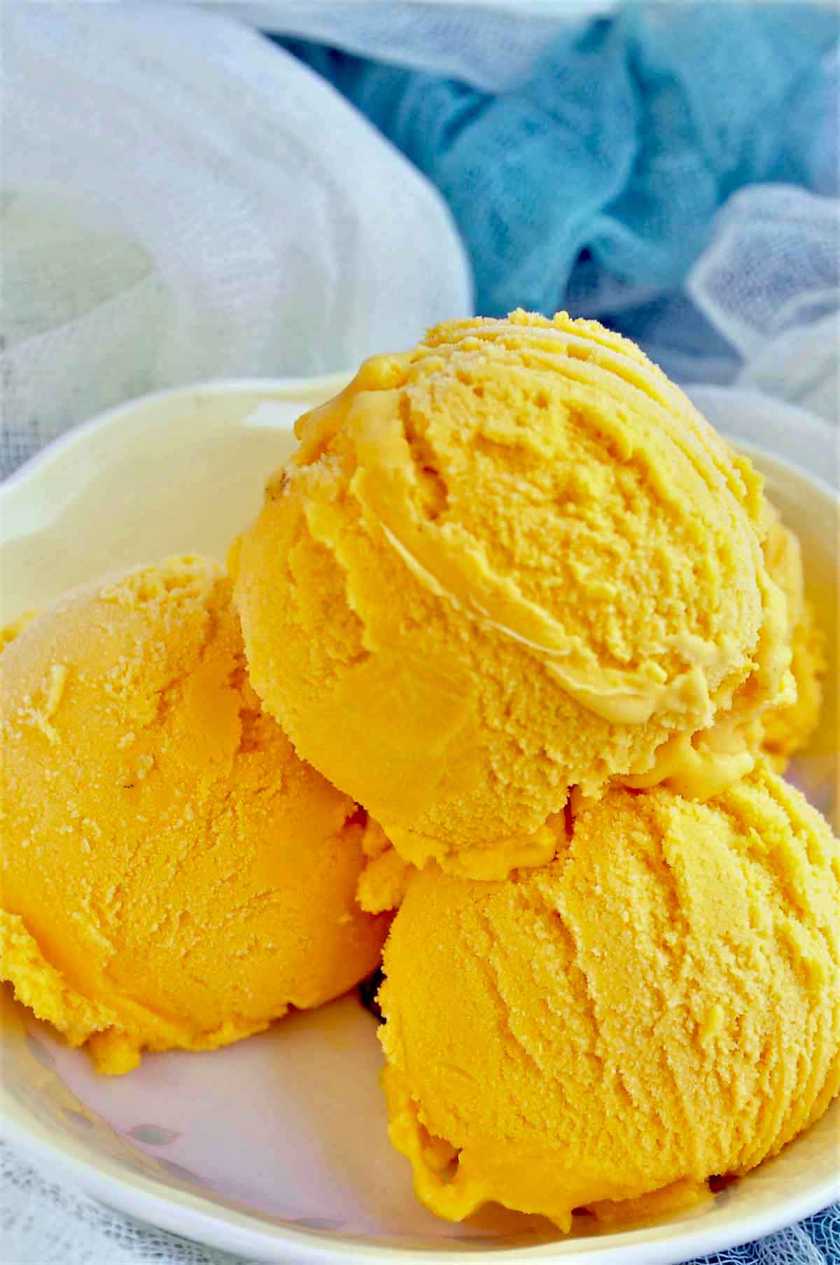 Mango flavor ice cream scoops in a bowl.