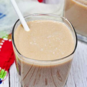 Chikoo milkshake served in a glass with straw,