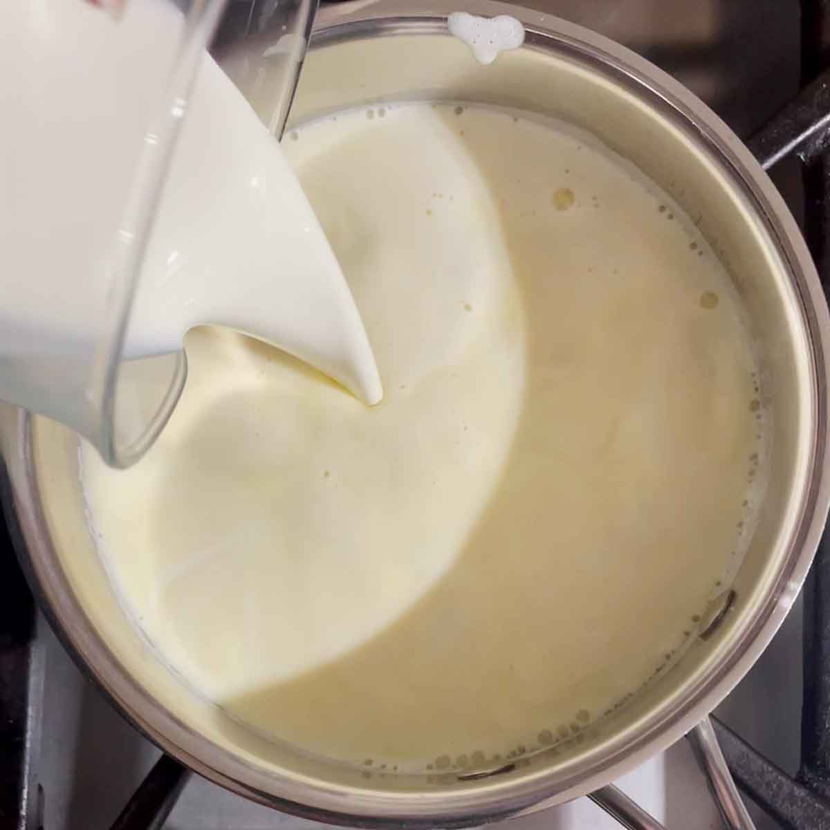 Adding heavy cream to custard.