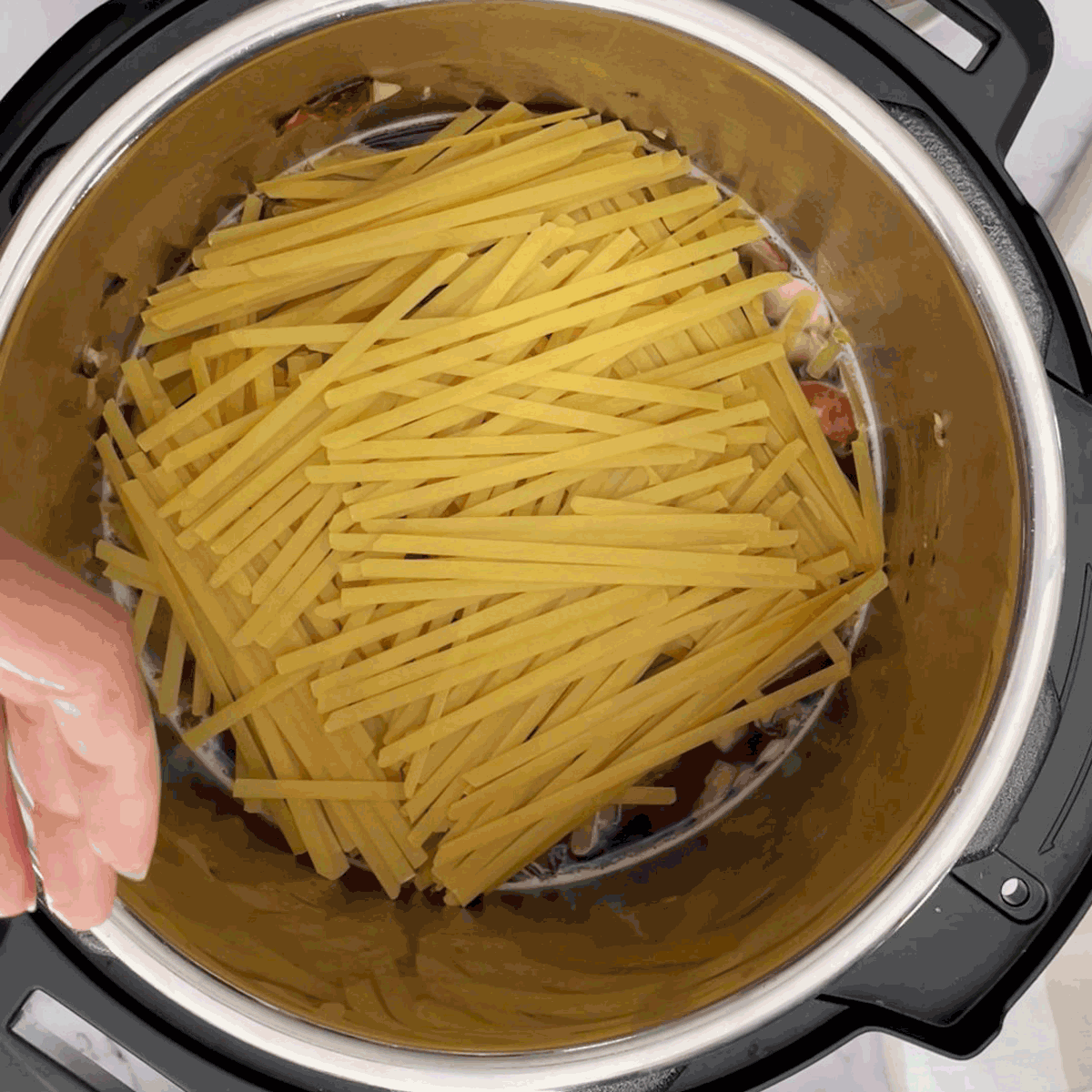 Lay down fettuccini pasta in the pot.