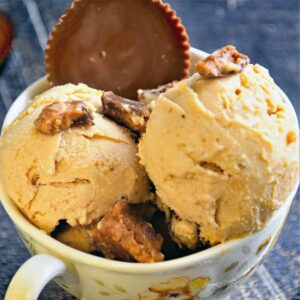 Peanut butter ice cream scoops served in a bowl with Reese's topping