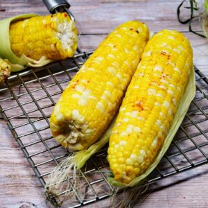 Air fryer corn on the cob on a grill rack.