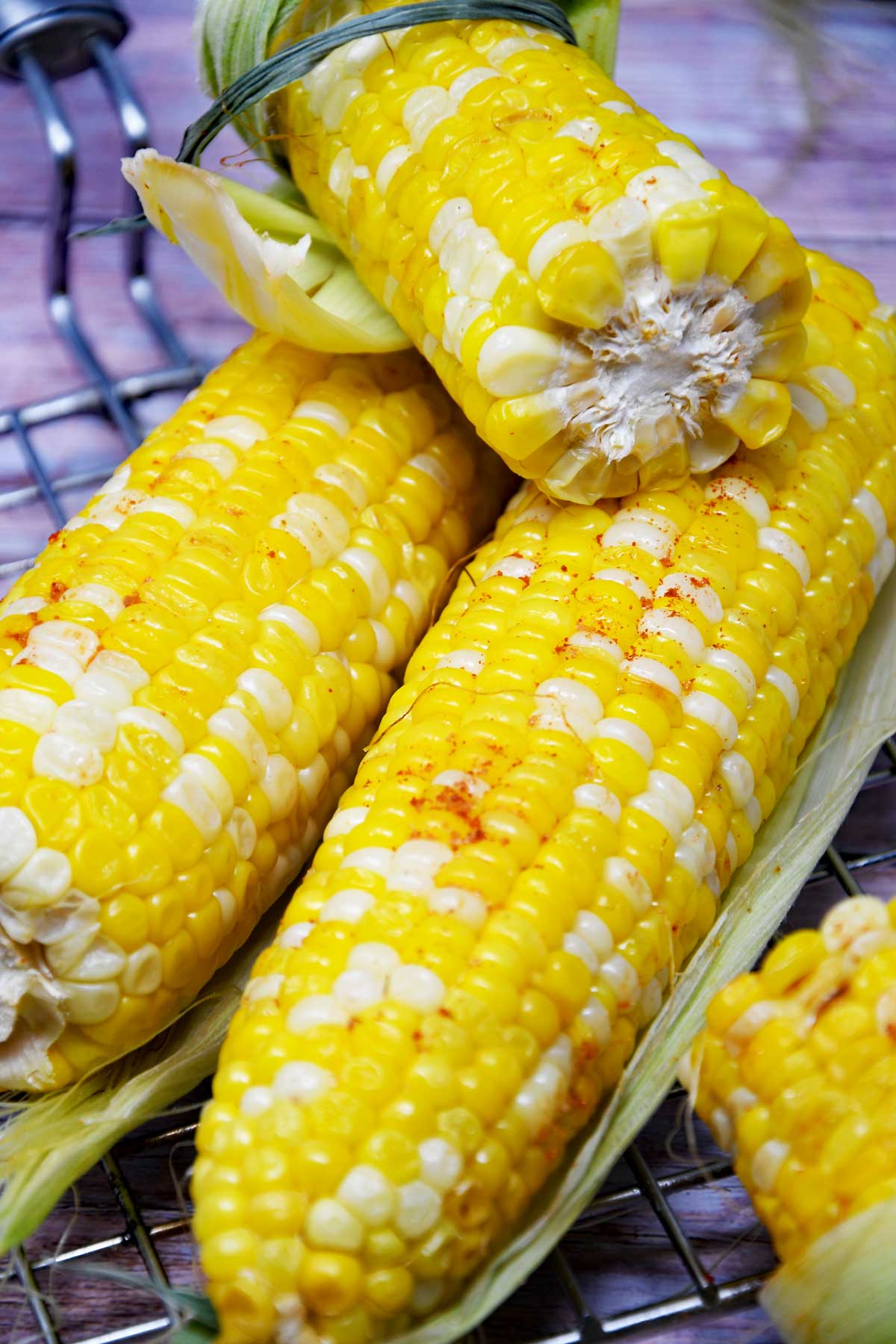 Air fryer corn on the cob on a grill rack.