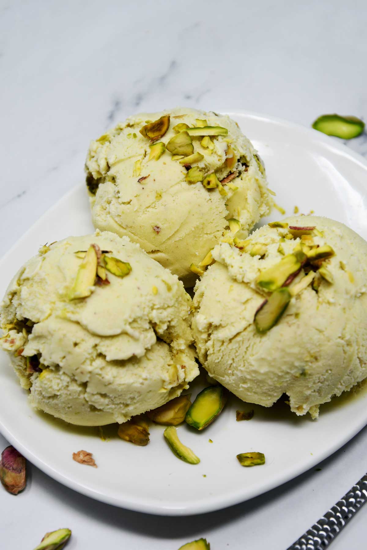 Pistachio ice cream scoops in a plate.