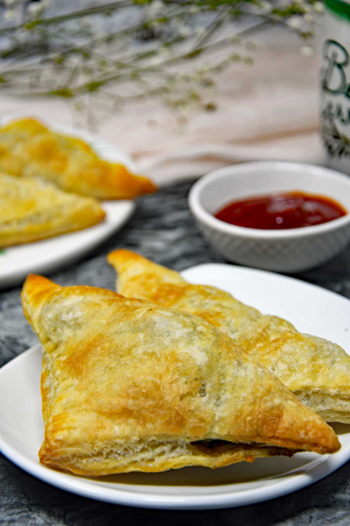 Air fryer puff pastries in a serving plate with ketchup.