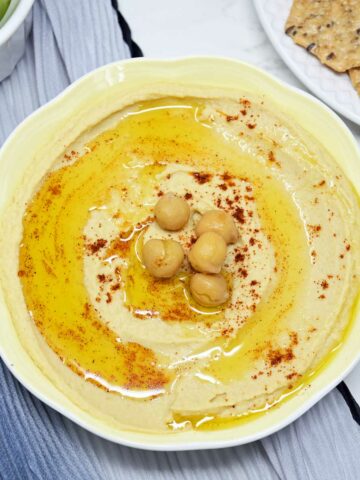 Hummus served in a shallow bowl with cracker and celery.