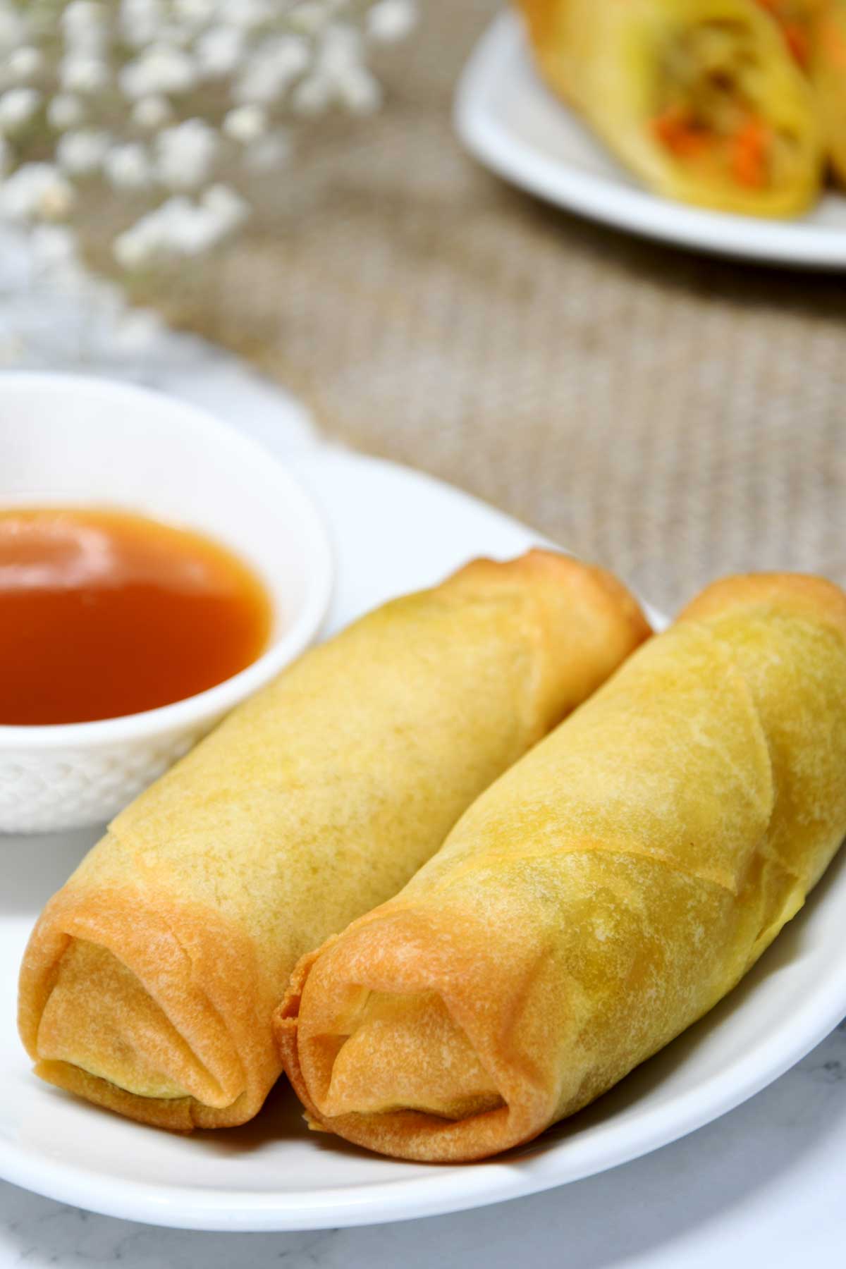 Air fryer frozen spring rolls served with sweet sauce.