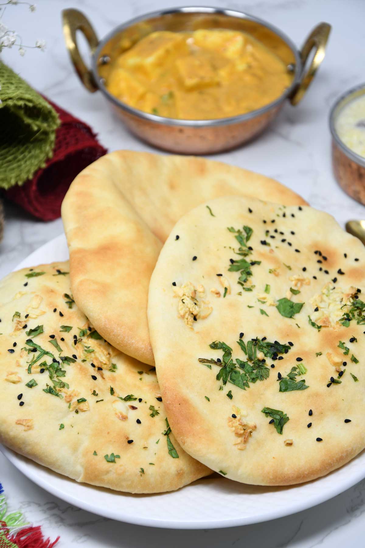 Air fryer naans served in a plate with paneer curry.