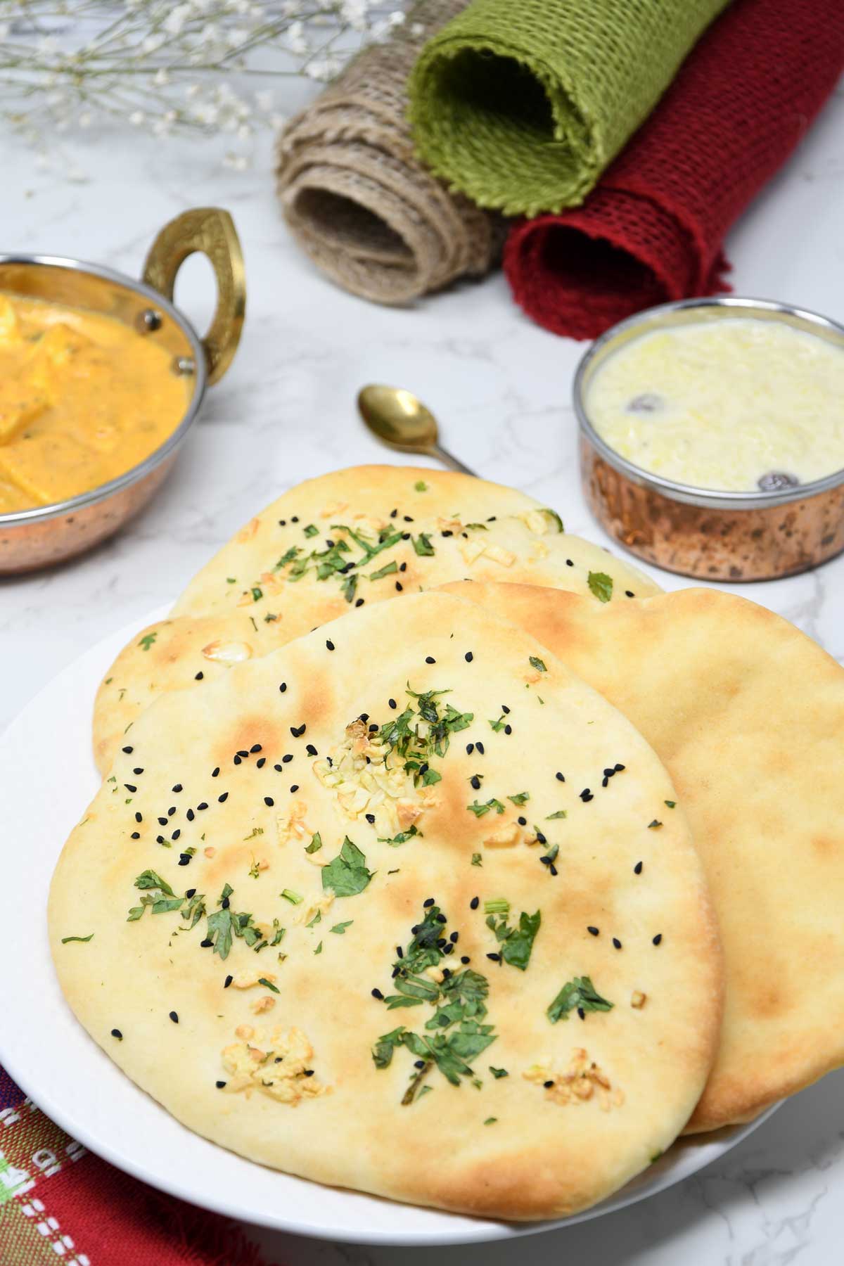 Air fryer naans served in a plate with paneer curry.