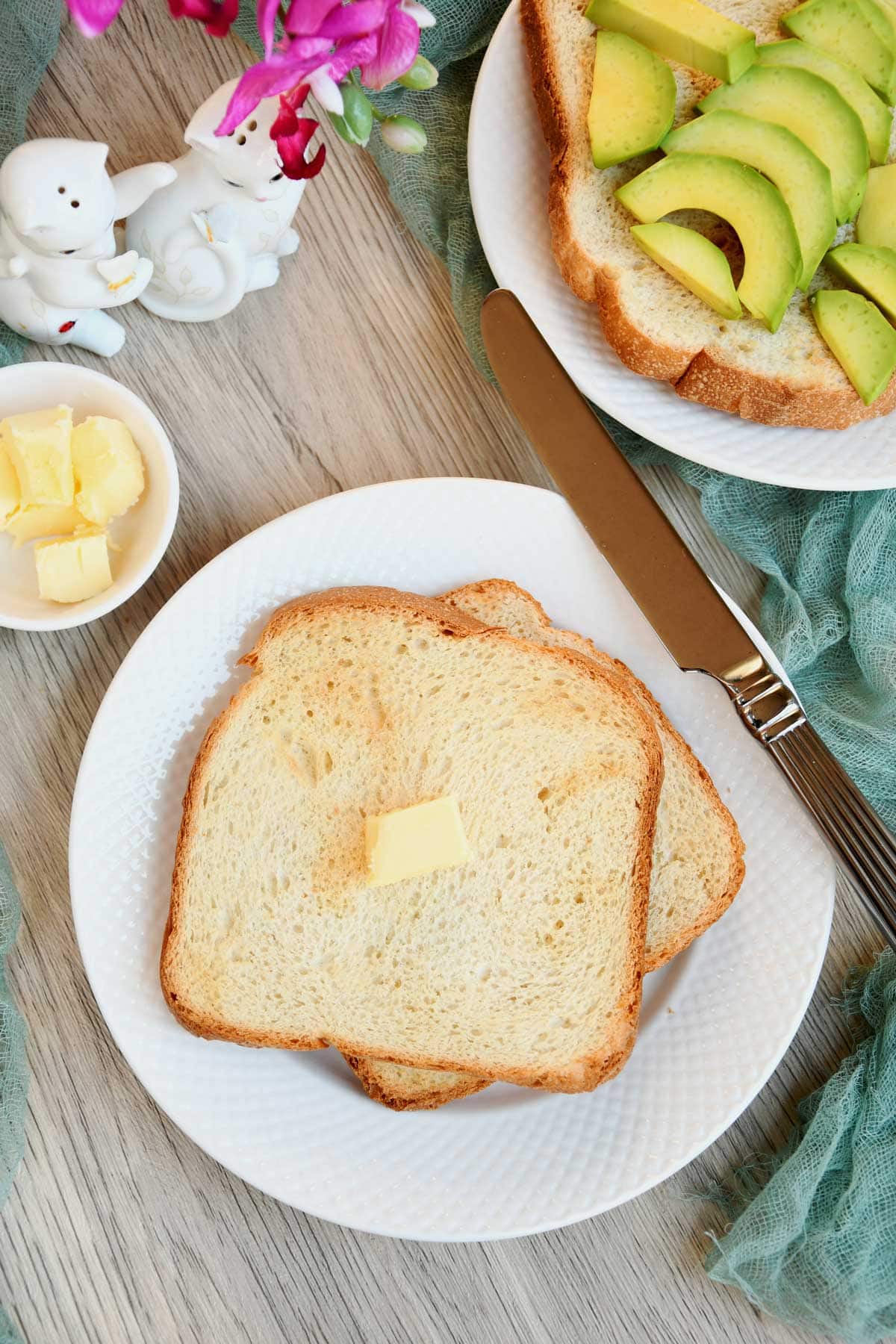 Air fryer toasted bread served on a plate with butter cube.