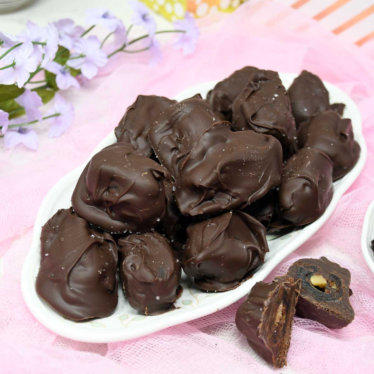 Chocolate covered dates served on a plate.