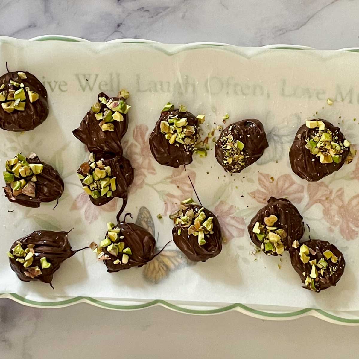 Chocolate coated apricot garnished with pistachios.