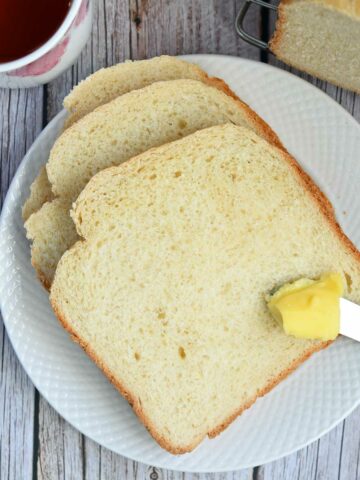 Milk bread slices with butter on butterknife.