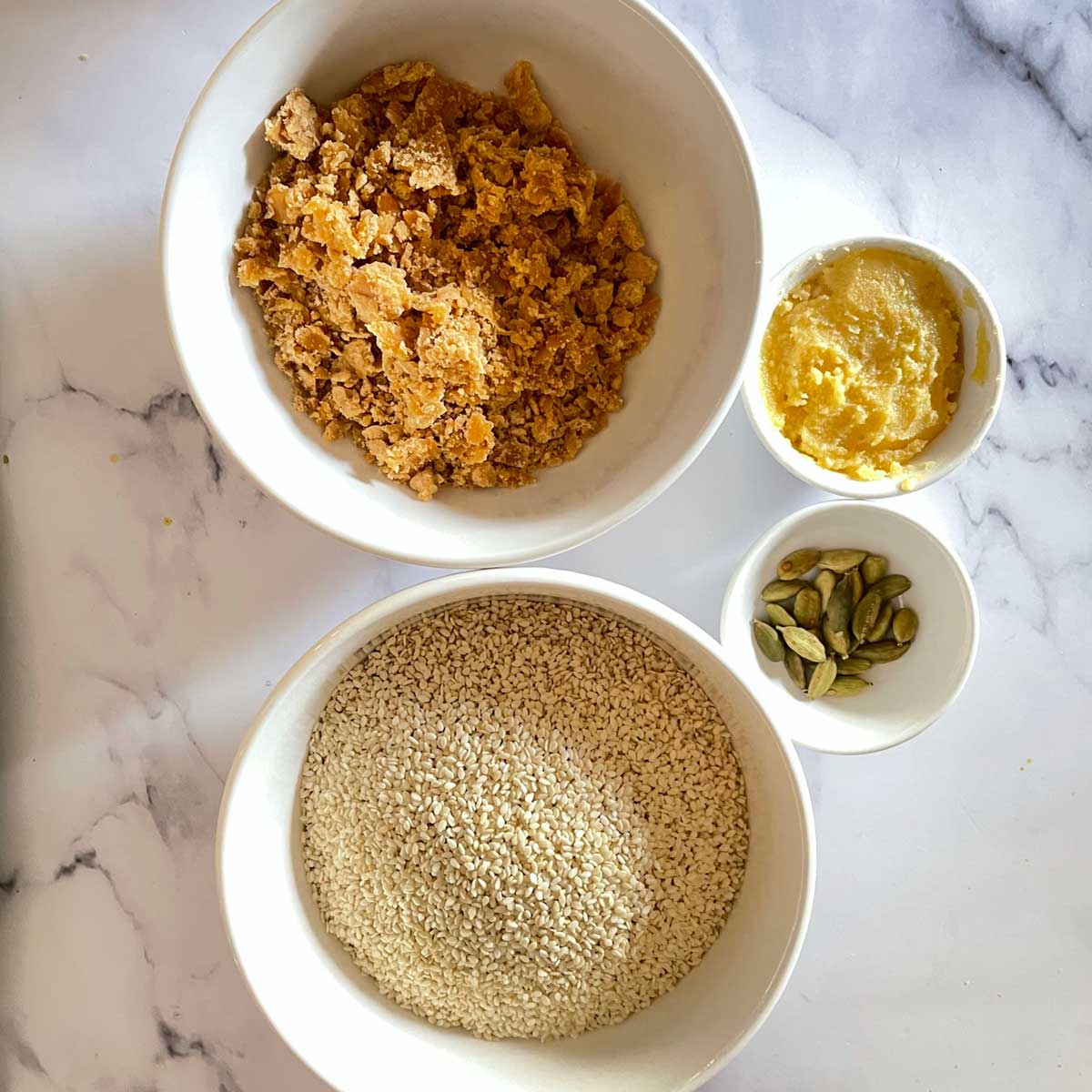 Sesame laddu ingredients in bowls.