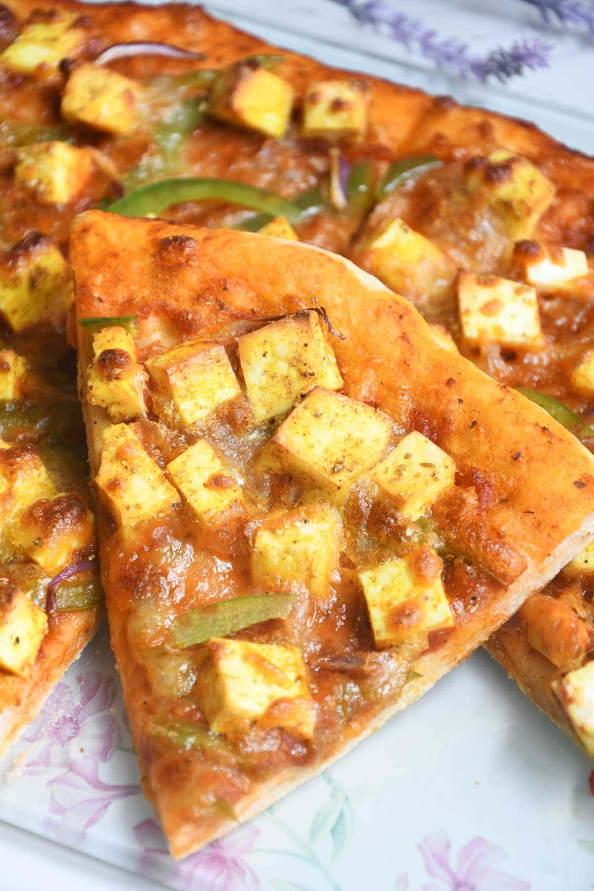Paneer pizza slices in a plate.
