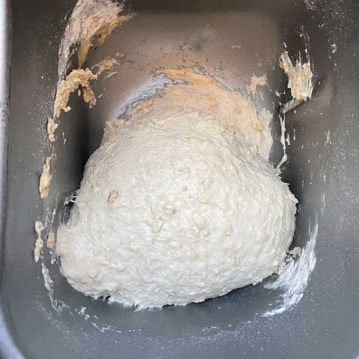 Oatmeal bread dough in bread machine pan.