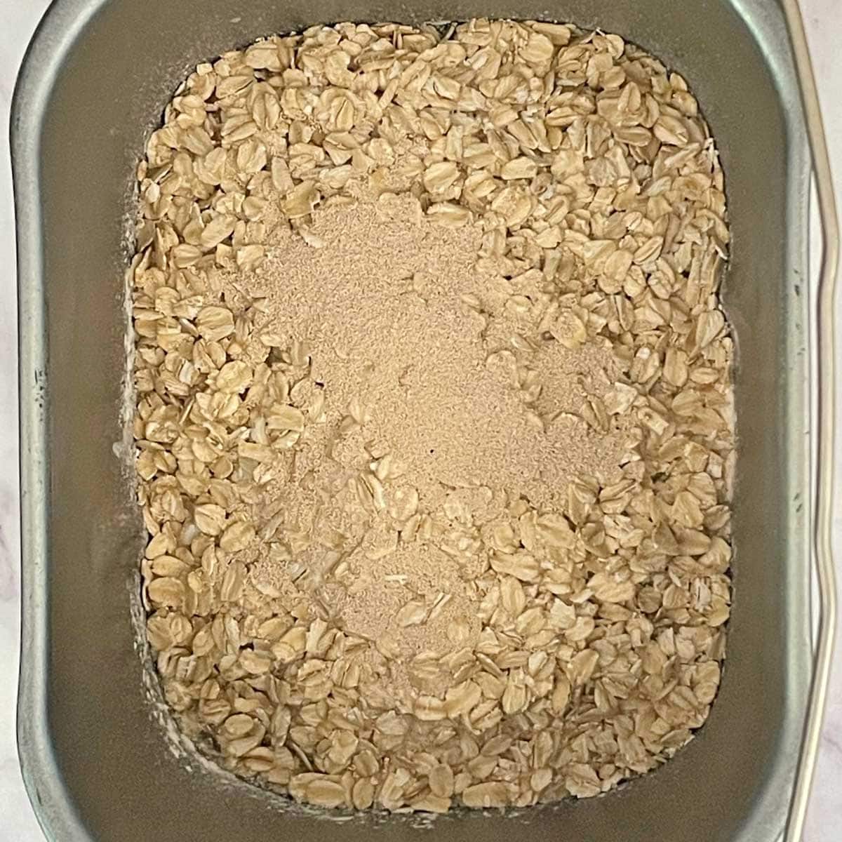 Oatmeal bread ingredients in bread machine pan.