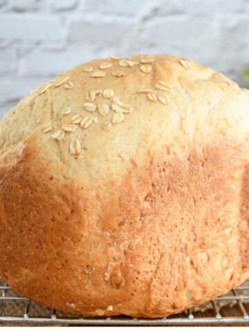 Oatmeal bread loaf on a cooling rack.