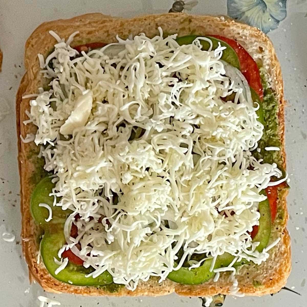 Mumbai sandwich layered with shredded cheese.