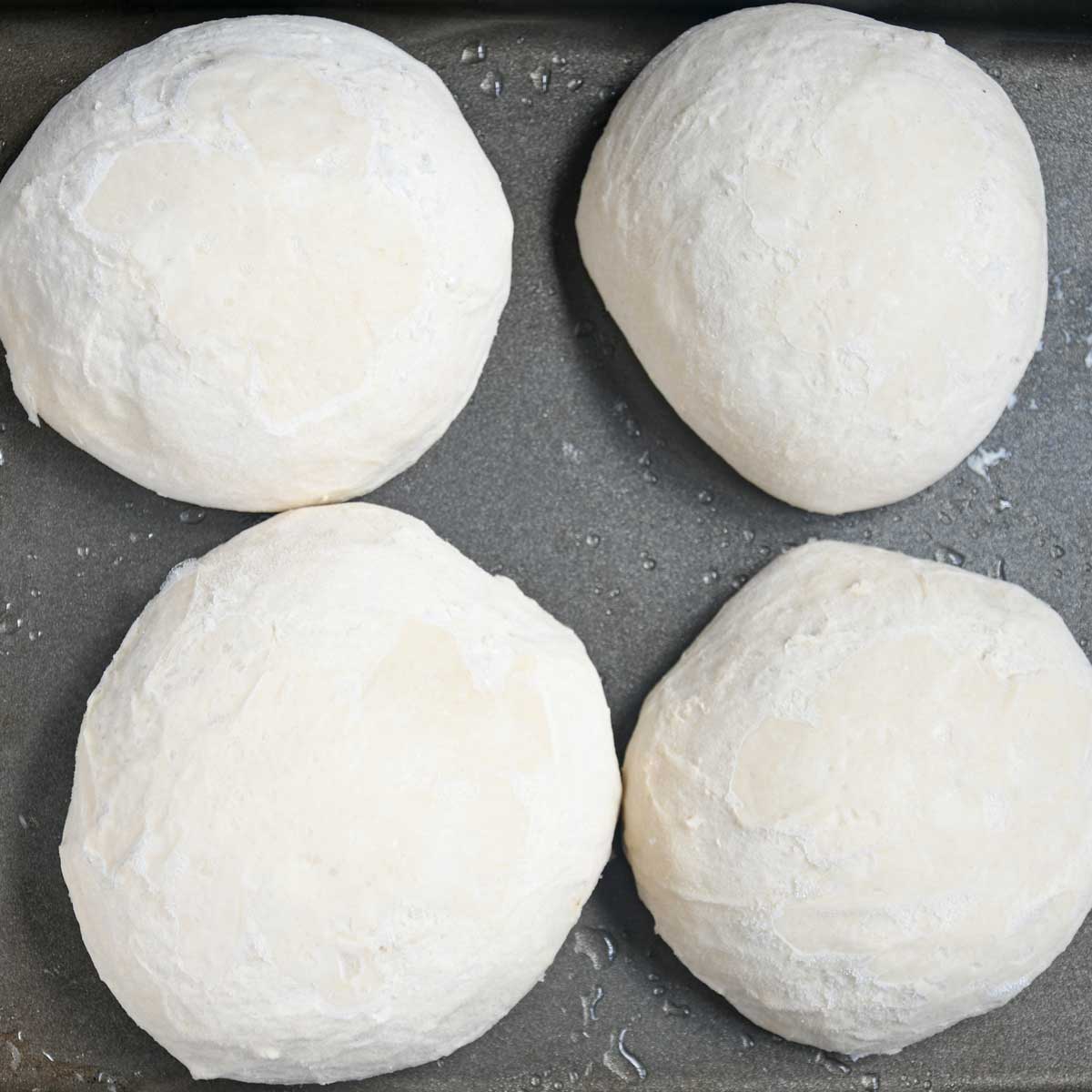 Frozen pizza dough in a tray.