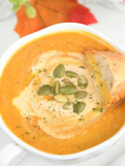 Pumpkin carrot soup in soup bowls.