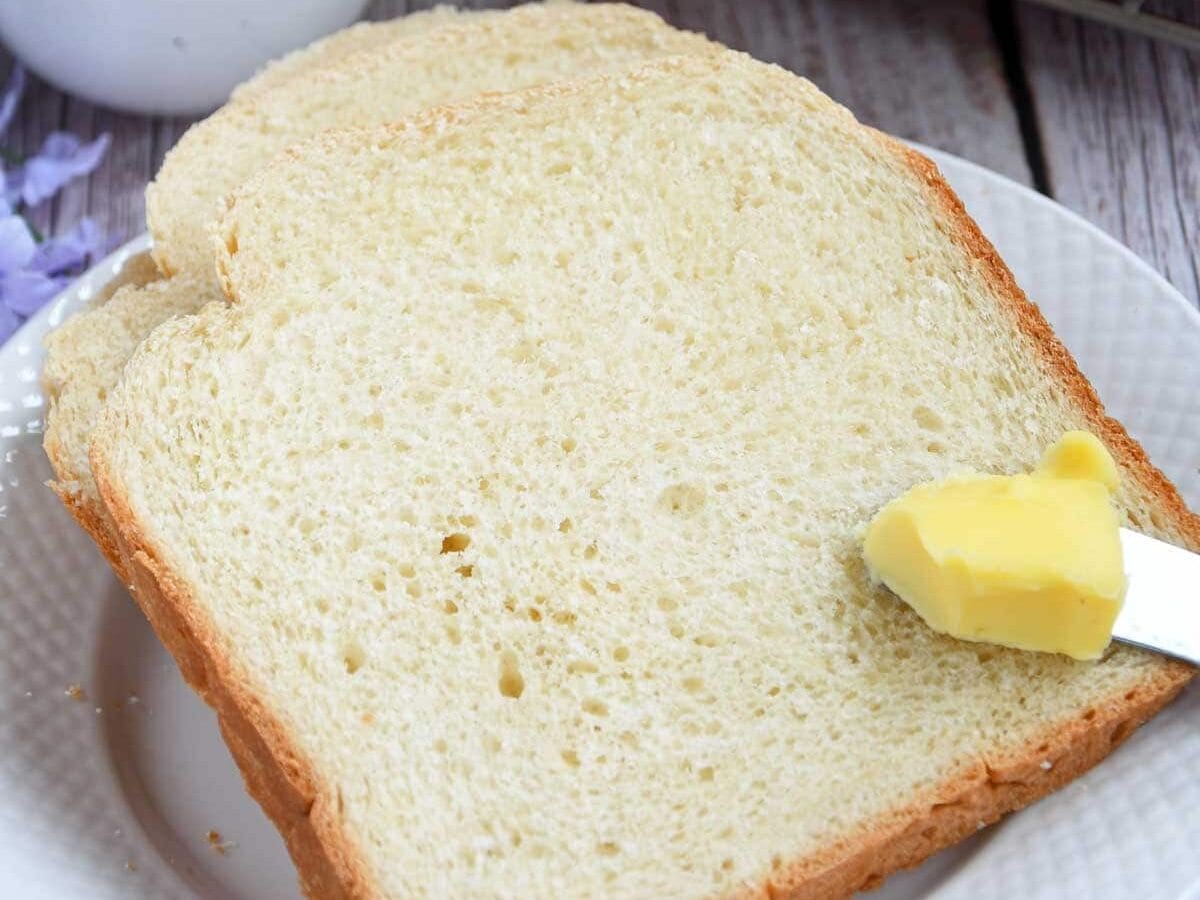 Milk bread slices with butter on butterknife.
